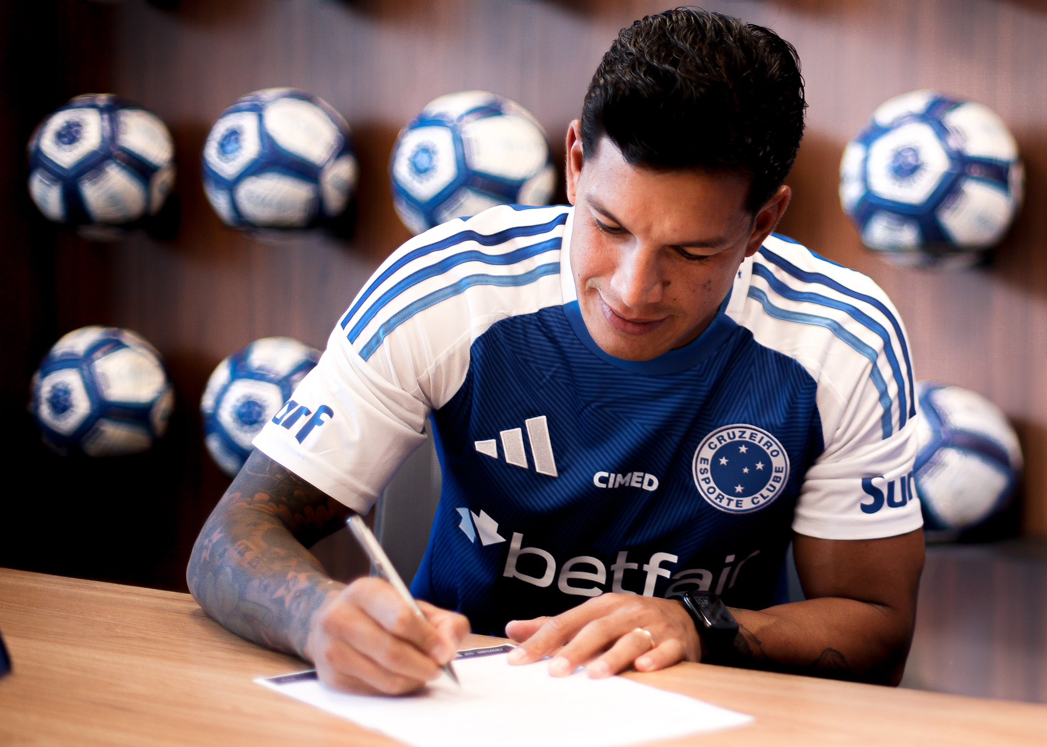 Lucas Romero assinando com o Cruzeiro