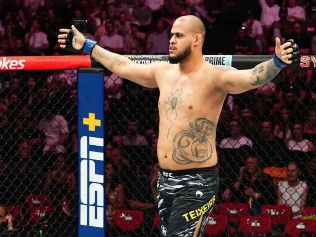 Lutador brasileiro Xicão, peso-pesado do UFC, dentro do octógono de braços abertos após vitória, diante do público na arena em Sydney, durante o UFC 325