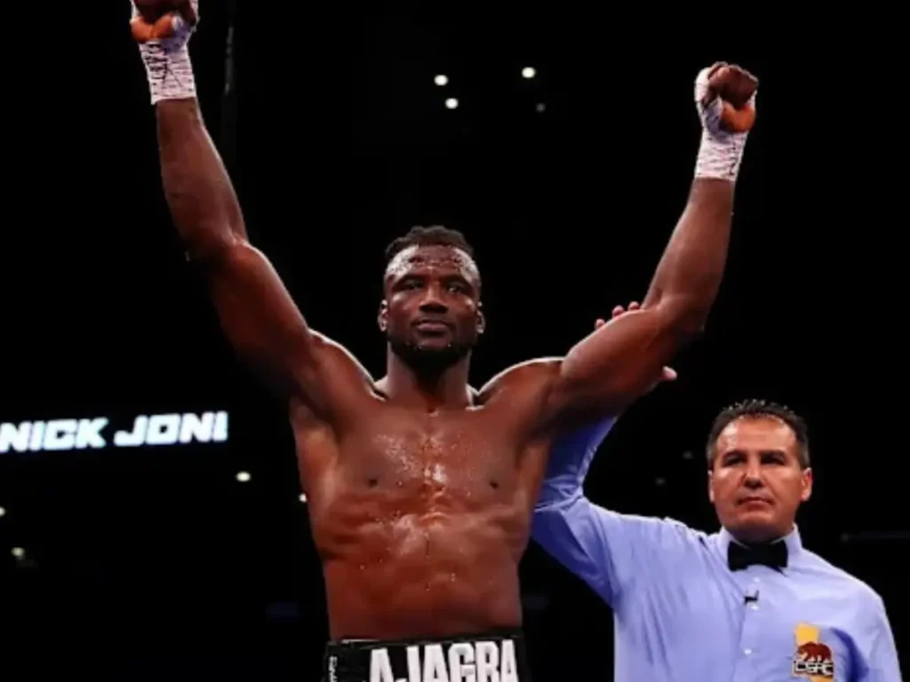 Efe Ajagba celebra a vitória por nocaute técnico sobre Charles Martin no centro do ringue do Meta Apex, enquanto o árbitro encerra o combate no quarto round do Zuffa Boxing 03